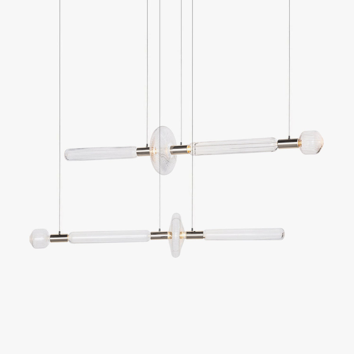 Two horizontal Clérachic pendants with fluted glass rods and round discs, shown lit on a plain white backdrop.