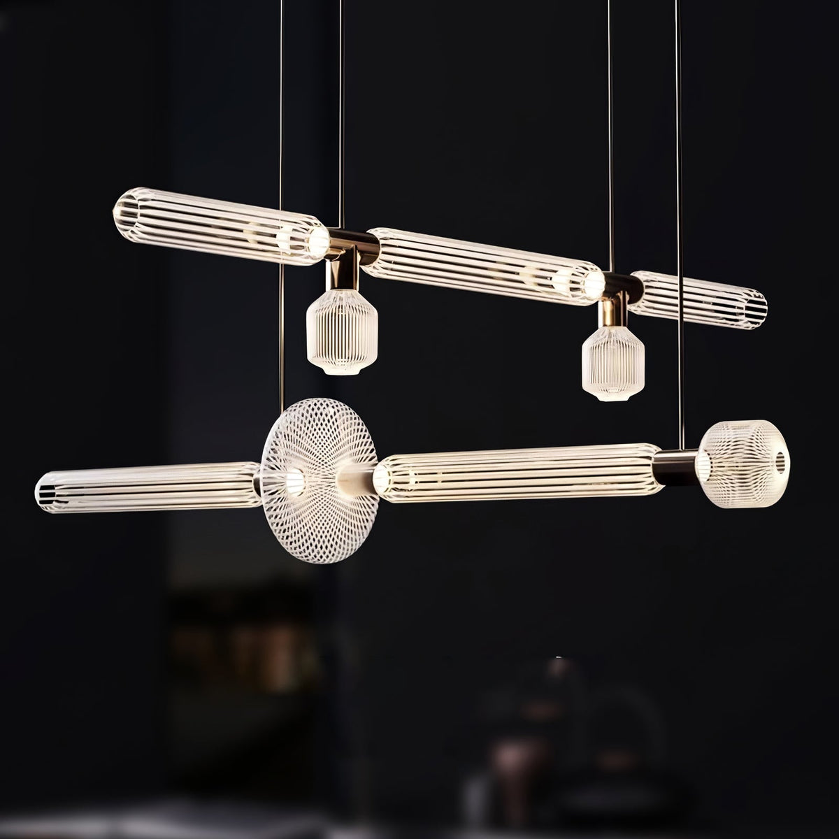 Two rods of this Clérachic pendant cross at a round disc joint in a dark room.