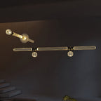 A Clérachic ceiling light combines a burst fixture and a linear bar of lit rods above a stairwell.
