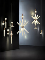 A cluster of Clérachic pendants, from single rods to full crystal bursts, lit against a black backdrop.