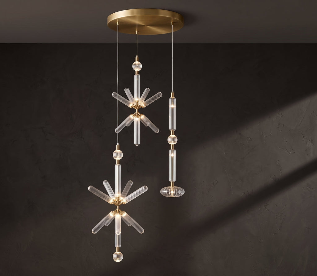 A crystal burst and a fluted rod, both Clérachic pendants, hang from a brass ceiling plate.
