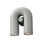 This grey Clérachic wall light stands unlit on a white backdrop, showing its U-shaped tube from the front.