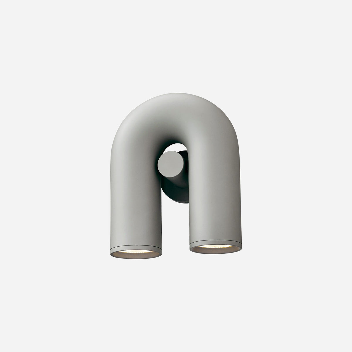 This Clérachic wall light in grey stands unlit against a light backdrop, its U-shaped tube in profile view.