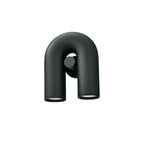This black Clérachic wall light turns slightly to show its profile, unlit against white.