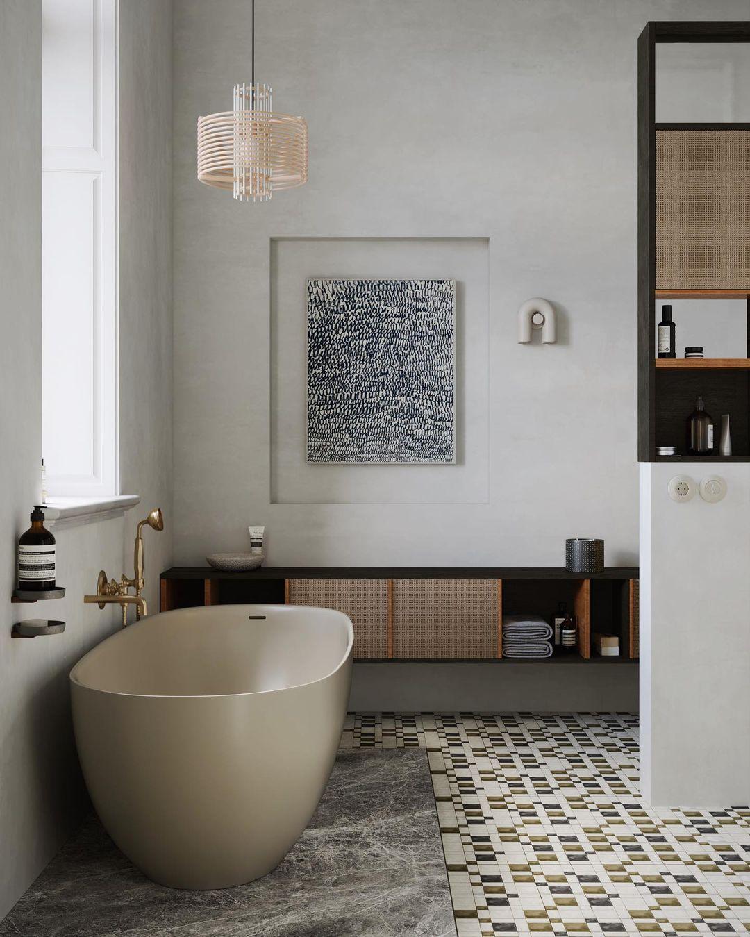 This Clérachic wall light sits small and pale on a bathroom wall, beside a freestanding tub and framed artwork.
