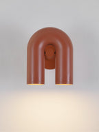 This Clérachic wall light in terracotta faces forward, unlit, against a plain light backdrop.