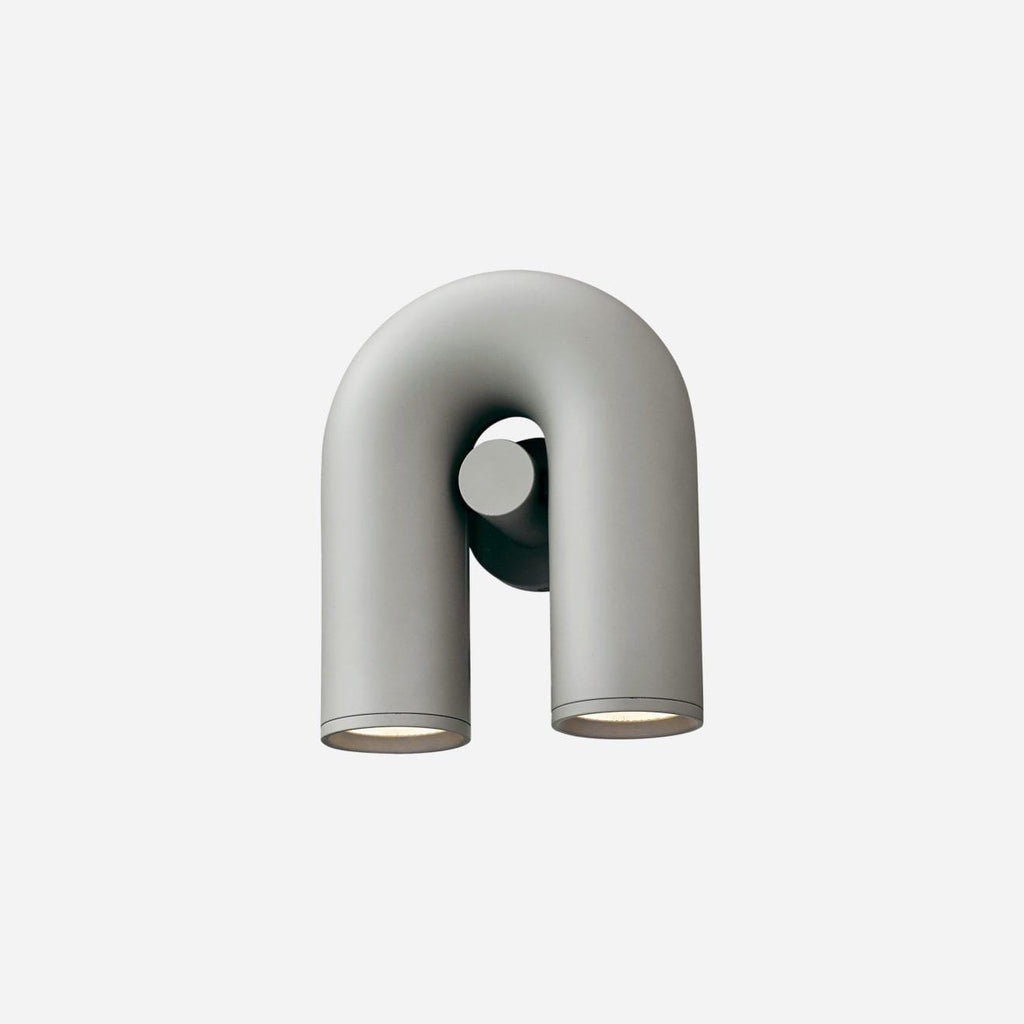 Three-quarter view of this grey Clérachic wall light, unlit, on a plain light backdrop.