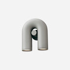 Three-quarter view of this grey Clérachic wall light, unlit, on a plain light backdrop.