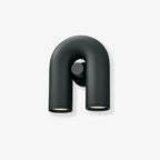 Front view of this Clérachic wall light in black, unlit, showing the U-shaped tube and swivel spotlight heads against a plain backdrop.