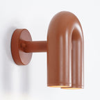 Viewed from the side, this terracotta Clérachic wall light shows its round mounting plate against white.