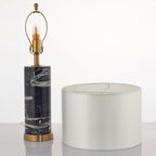 This Clérachic table lamp is shown apart from its shade, the bare bulb and brass socket set beside the drum shade.