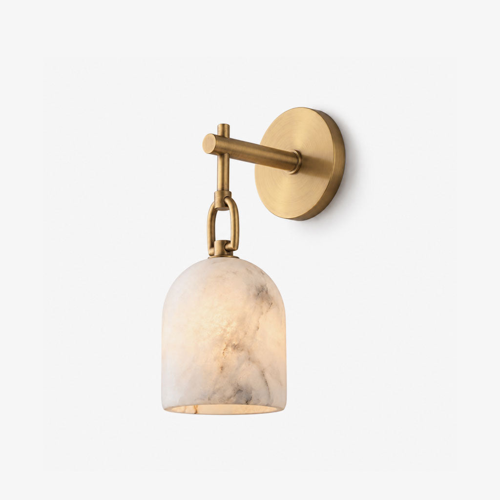 A brushed-brass Clérachic wall sconce displays its chain-hung alabaster dome shade on a plain white backdrop.
