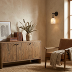 Unlit in matte black, this Clérachic sconce sits above a reclaimed-wood sideboard flanked by a tan leather armchair.
