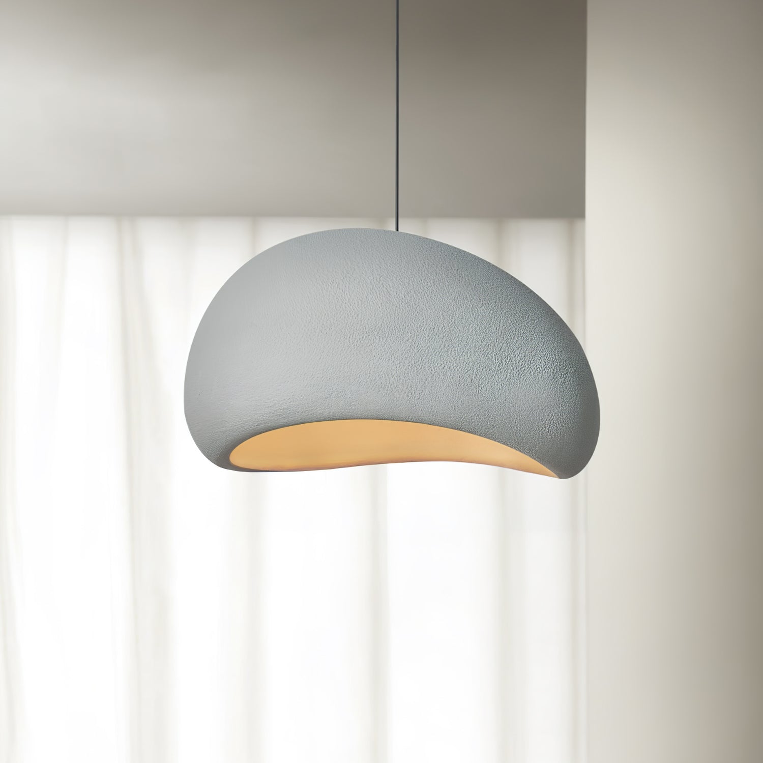 Cloud pendant light hanging from a thin cable with warm glow