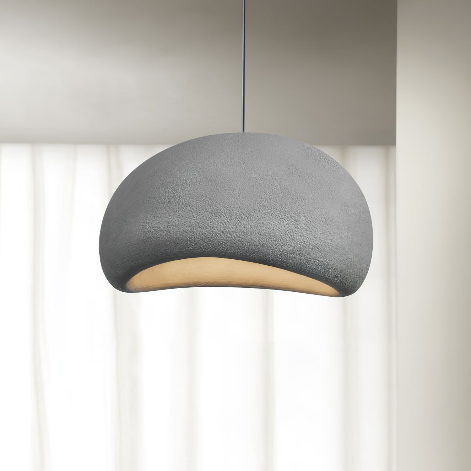 Sphere cloud pendant light glowing gently against a neutral ceiling