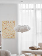 Unlit, this Clérachic cloud-shaped pendant hangs in a bright room with sheer curtains and a cushioned bench.