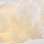 A close view shows the creased, puffy fabric texture of this Clérachic cloud pendant, lit warm.