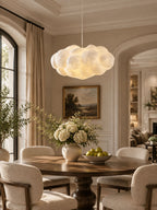 This Clérachic cloud pendant lights a dining room with a round table set with hydrangeas.