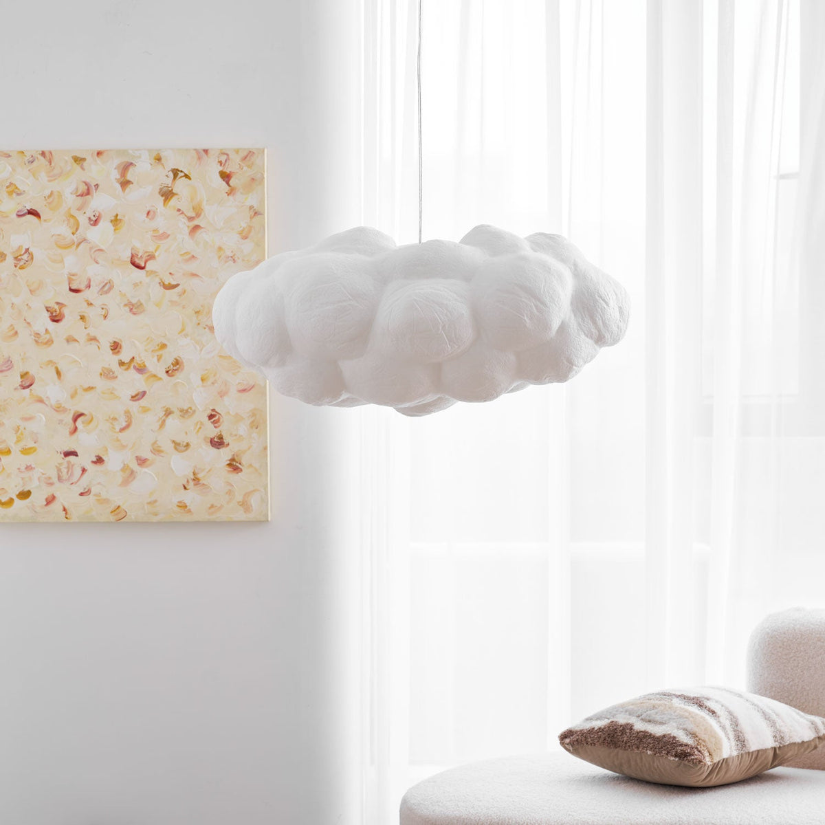 Set against a plain wall, this unlit Clérachic cloud-shaped pendant hangs beside a framed floral print.