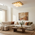 Above a cream sectional sofa with a wood coffee table, this Clérachic ceiling light clusters warm in brushed brass.