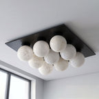 From a close angle on a plain backdrop, this Clérachic ceiling light's globes sit against a matte black canopy.