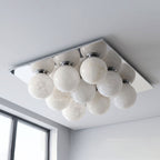 Against a plain white backdrop, the alabaster globes of this Clérachic ceiling light sit on a brushed nickel canopy.