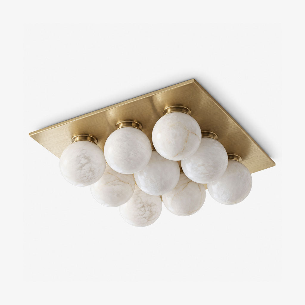 Shown alone against a plain backdrop, the clustered alabaster globes of this Clérachic ceiling light sit in brushed brass.
