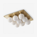 Shown alone against a plain backdrop, the clustered alabaster globes of this Clérachic ceiling light sit in brushed brass.