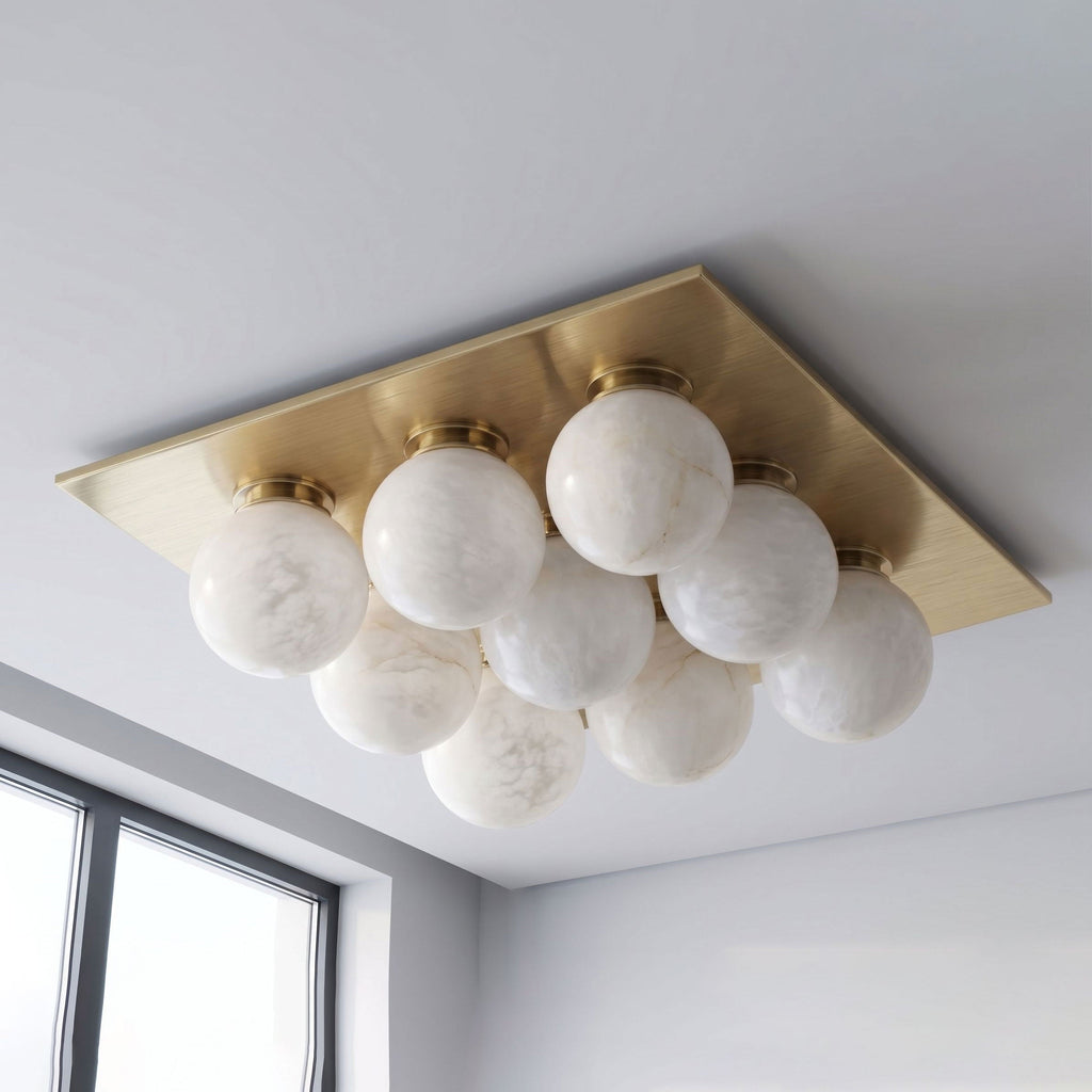 Seen from below on a plain backdrop, the tight globe cluster of this Clérachic ceiling light shows in brushed brass.
