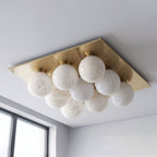 Seen from below on a plain backdrop, the tight globe cluster of this Clérachic ceiling light shows in brushed brass.