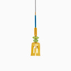 A single amber fluted glass bell shade hangs below a green bead on this Clérachic pendant, shown on white.