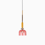A single coral ribbed bell shade hangs from an amber stem on this Clérachic pendant, shown on a plain background.