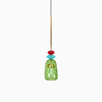 A single green ribbed bottle shade hangs below a red glass bead on this Clérachic pendant, isolated on white.