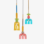 Amber, teal and coral bell shades cluster together at different heights on this Clérachic pendant set, shown on white.