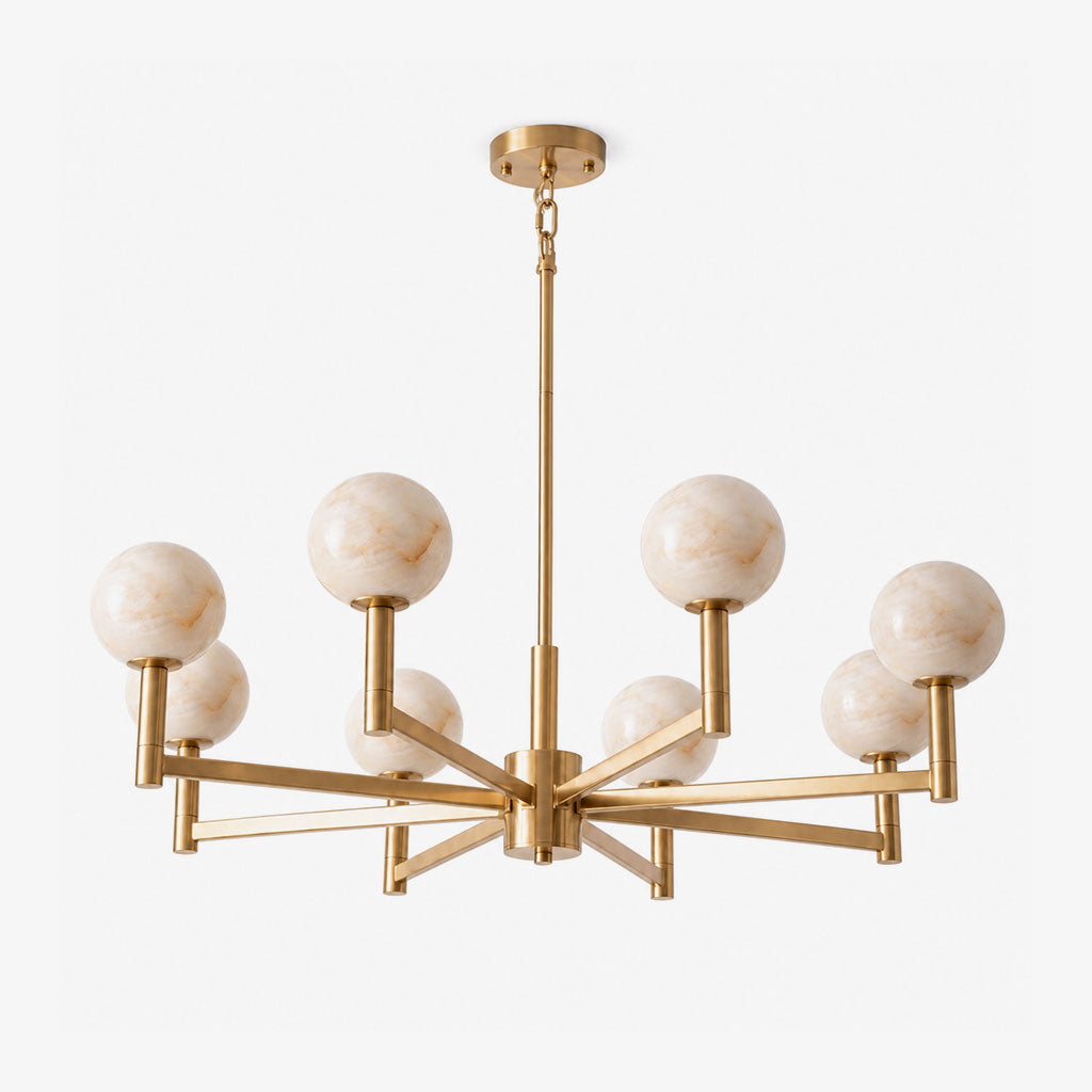 Seen close on a plain backdrop, this Clérachic chandelier's brass arms cross at angles beneath their alabaster globes.