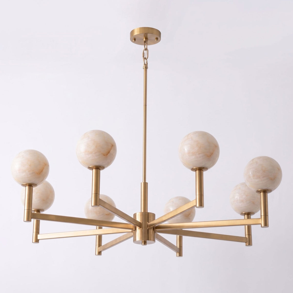 Set on a pale lavender backdrop, this Clérachic chandelier's brass frame holds eight alabaster globes at staggered heights.
