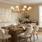 Under a gold-toned abstract painting and beside a wood sideboard, the brass-finish chandelier from Clérachic lights a dining table.
