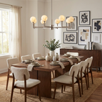 In front of a gallery wall above a dark wood dining table, the nickel finish of this Clérachic chandelier catches the light.