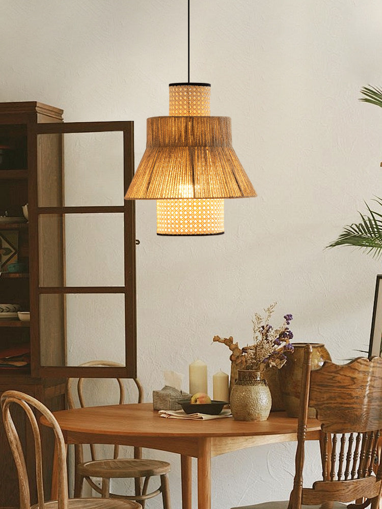This Clérachic pendant glows warm near a glass-front cabinet, above a table dressed with dried flowers in a jug.
