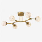 Photographed against white, this Clérachic chandelier shows its full branching brass frame and six alabaster ball shades.