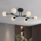 Photographed in matte black against white, this Clérachic chandelier's six arms fan out at differing lengths.