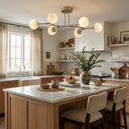 Above a wood kitchen island with a vase of eucalyptus, this brass Clérachic chandelier branches across the ceiling.