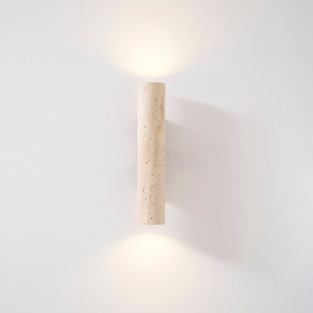 Centred in the studio frame, this Clérachic wall light glows lit against a plain grey wall.