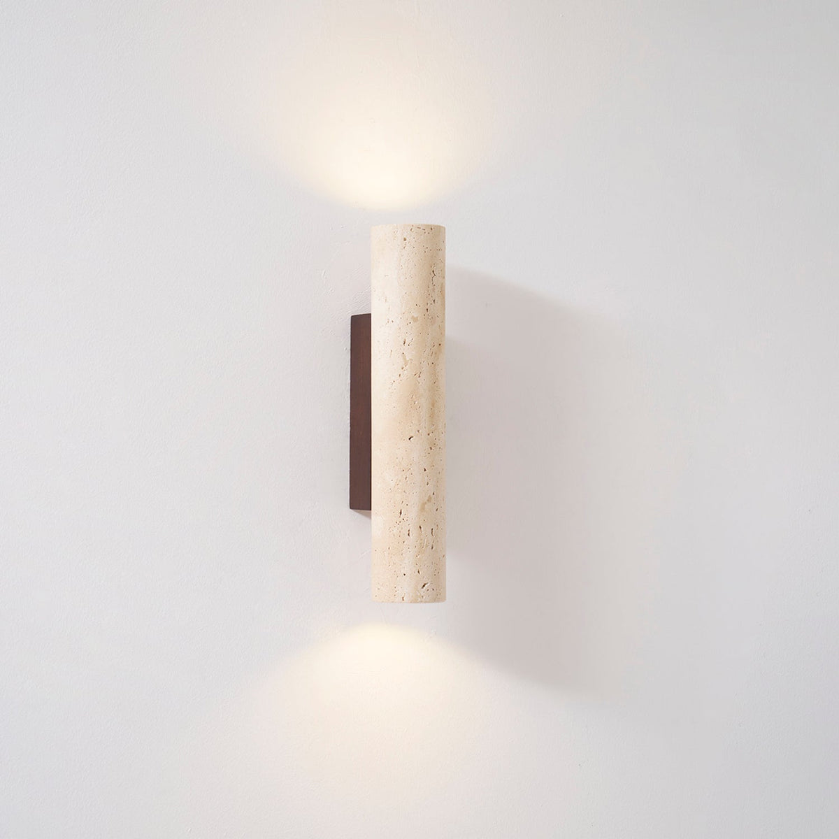 A sliver of the walnut mount peeks from this Clérachic wall light, lit, in the studio.