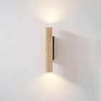 This shorter Clérachic wall light glows lit in the studio, set against a grey backdrop.
