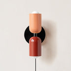 Couleur Double wall lamp shown beside soft home furnishings