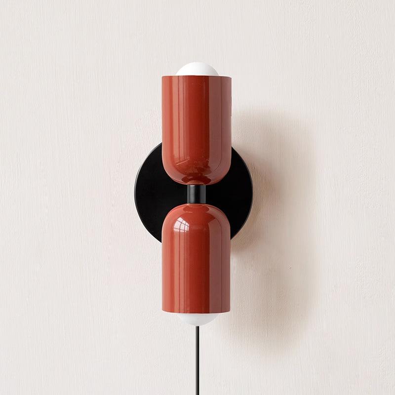 Plug-in wall lamp casting a soft up and down glow on a wall