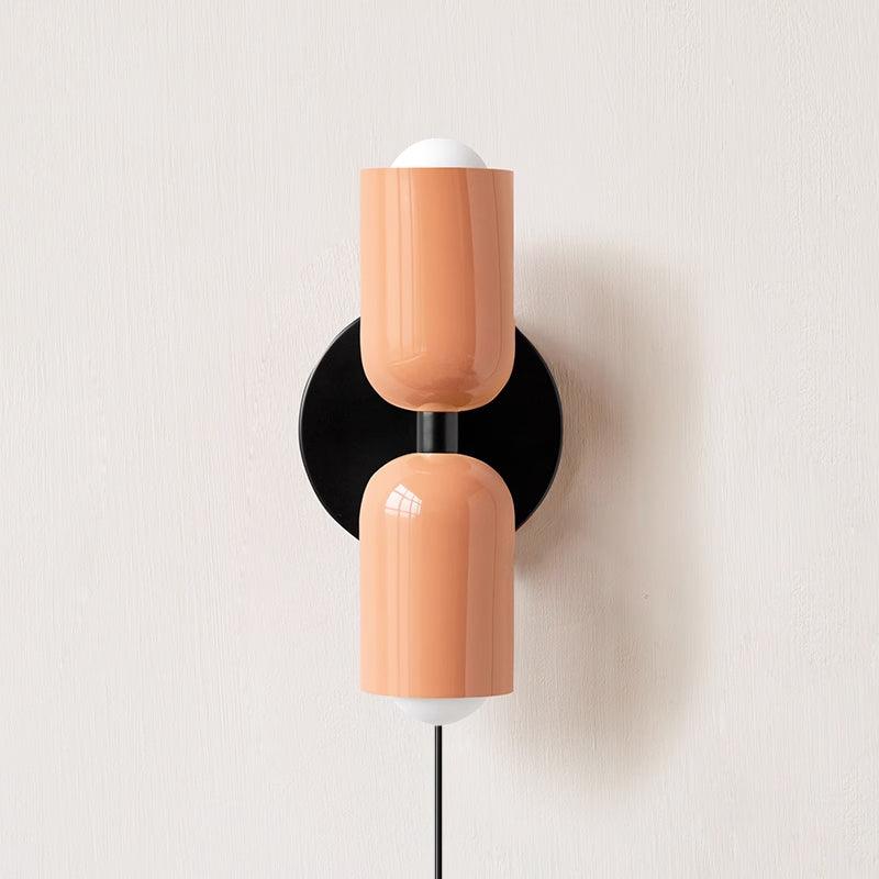 Plug-in wall lamp with coloured shade lighting a styled corner