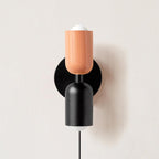 Coloured shade wall lamp casting layered light on a wall