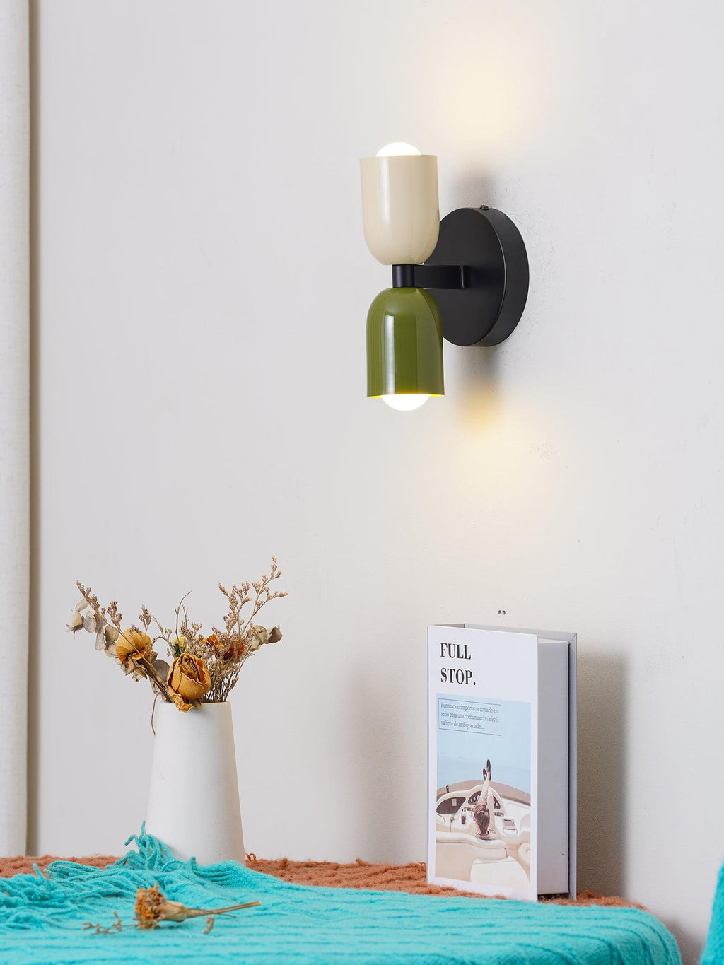 Wall lamp with metal shade lighting a room corner